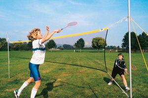 Freizeit-Badmintonnetz mir 2 Spielerinnen auf Rasen